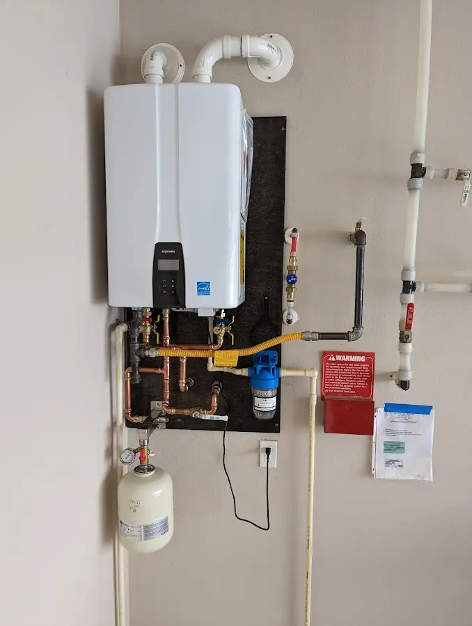 Professional plumber installing copper piping in a Meridian Village home